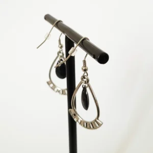 Boucles d'oreilles argentées et noires, en forme de gouttes, avec des pampilles noires au centre.