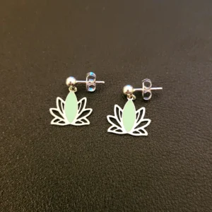 Clous d'oreilles argentés pendantes avec un lotus ajouré couleur menthe, vus de côté